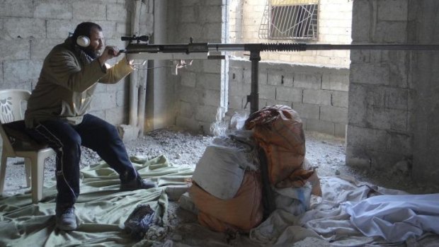 A Free Syrian Army fighter aims a locally made weapon in eastern Ghouta, Damascus. 