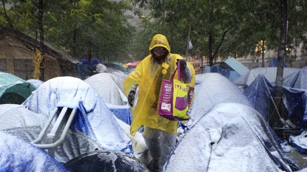 Winter, but no wonderland ... a member of the Occupy Wall Street movement in New York struggles out of his tent to find a warmer bolt-hole.