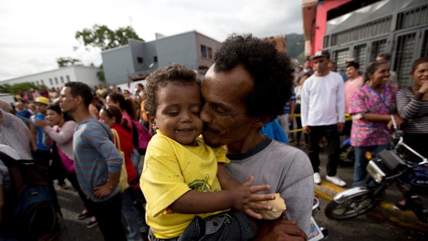 A man kisses his baby during a protest for food in Caracas, Venezuela. 