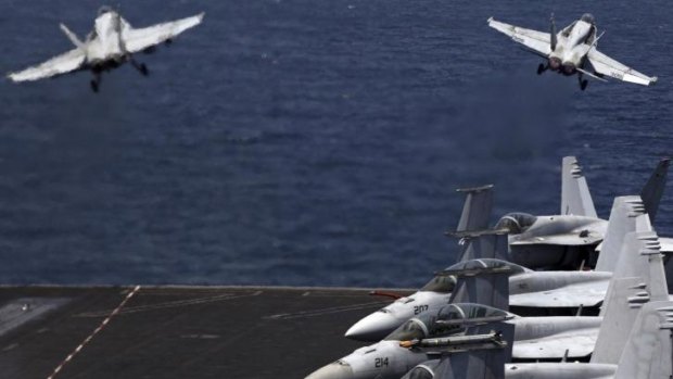 Air strikes: F/A-18 fighters take off for missions in Iraq from the deck of the USS George H.W. Bush.