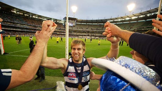 First of many heroes: Tom Lonergan shares the moment with jubilant Geelong supporters.