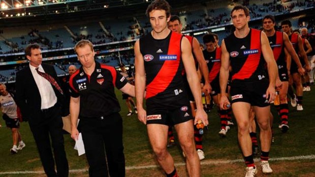 Essendon coach Matthew Knights walks off the field with  captain Jobe Watson and team after another loss.