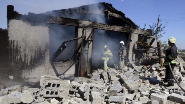 Firefighters work to extinguish a fire after shelling by pro-Russian militants on the outskirts of the small southern Ukrainian city of Novoazovsk.