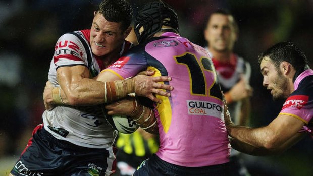 War of attrition: Luke O'Donnell of the Roosters is tackled by Gavin Cooper of the Cowboys.