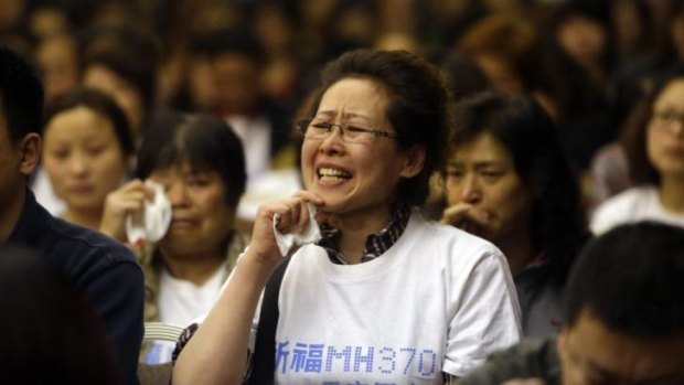 Many false leads ... A relative of a passenger aboard Malaysia Airlines Flight MH370 cries as she speaks to Malaysian representatives during a briefing at Lido Hotel in Beijing.