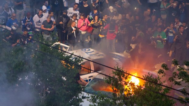 Rioters burn police cars after the Vancouver Canucks were defeated by the Boston Bruins.