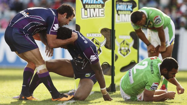 Feast and famine: Storm captain Cameron Smith congratulates Sisa Waqa on a try as Raiders players regroup.