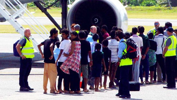 The asylum seekers pictured getting on board an aeroplane at Cocos Island, on their way to mainland Australia.