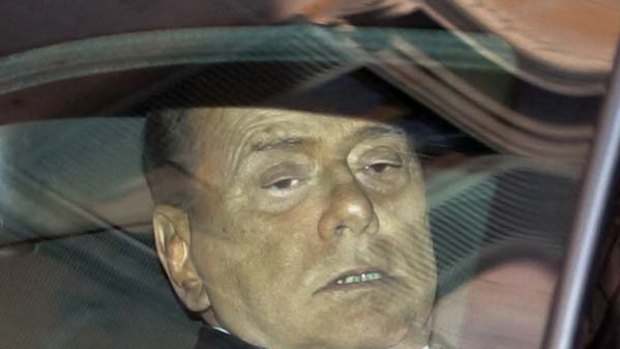 Under fire ... Silvio Berlusconi arrives at his home in Rome.