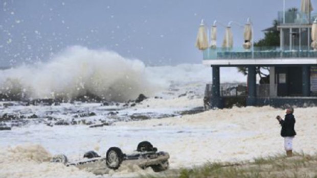A car lies on its roof near Queensland's storm-lashed Currumbin Surf Club yesterday.
