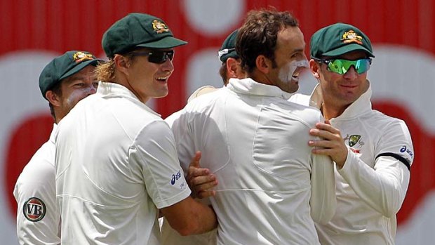 Spin bowler Nathan Lyon, centre right, is congratulated by teammates Shane Watson, centre left, Matthew Wade, left, and Australia captain Michael Clarke after taking the wicket of Carlton Baugh.