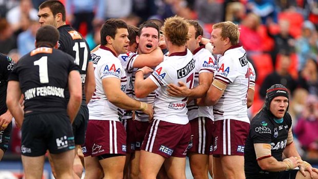 Jamie Lyon celebrates with Manly teammates after scoring a try.