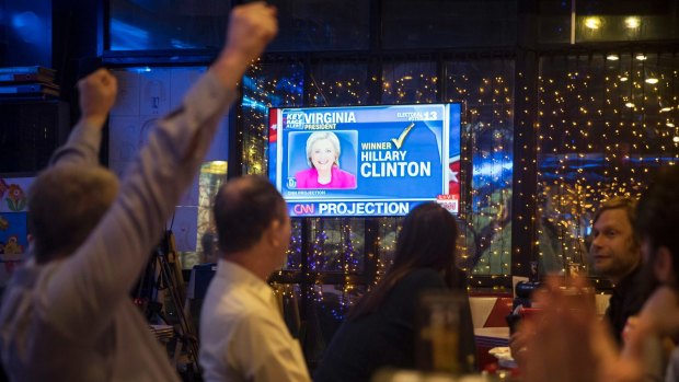Andrew Hardisty of the US, left, and other people react as they watch a live telecast of the US presidential election in a cafe in Moscow.