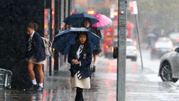 A student takes shelter in Sydney on Friday.