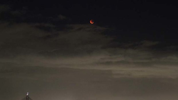 Total lunar eclipse ... the moon glows red over Sydney this morning.
