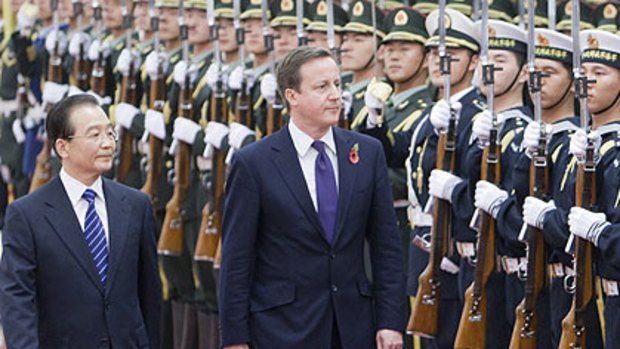 David Cameron - wearing the poppy - inspects Chinese troops in Beijing with China's Premier Wen Jiabao