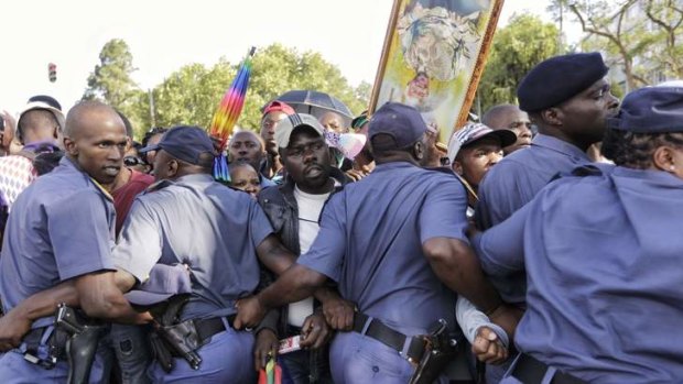 Police officers try to control the crowd in Pretoria.