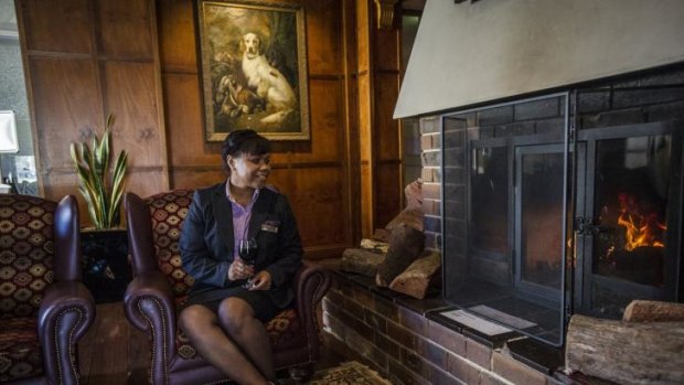 Nancy Alexander enjoys the fireplace at the Mercure Hotel Canberra