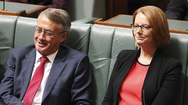 Political victory for Labor: Wayne Swan and Julia Gillard listen to Tony Abbott agreeing to honour tax cuts.