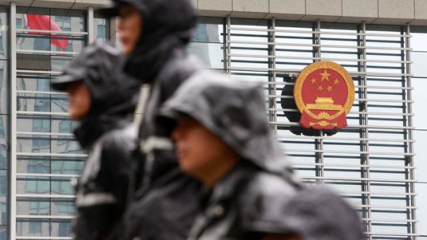 Public security personnel guard the perimeters of the Hefei Municiple Intermediary People's Court during the trial of Gu Kailai in 2012.