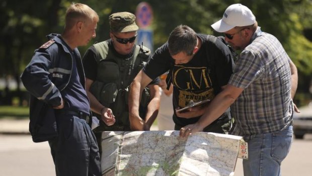 Treading a careful diplomatic path: OSCE monitoring staff talk with pro-Russian rebels in Donetsk.