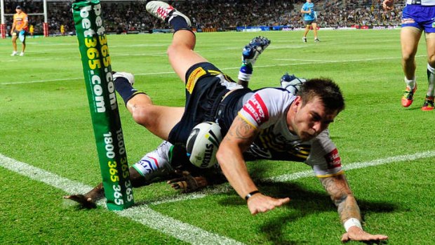 Tangled up in green: Kyle Feldt of the Cowboys scores a try against the Raiders on Saturday night.