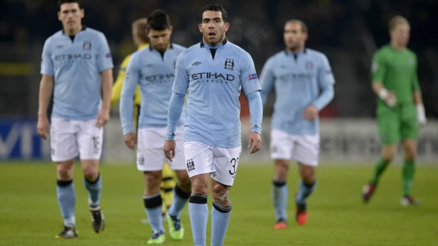 Out of Europe .. City's Carlos Tevez and his teammates leave the pitch after losing to Dortmund.