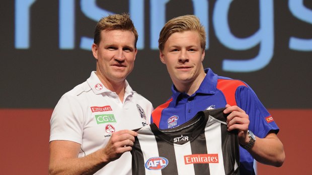 Jordan De Goey receives his jumper from coach Nathan Buckley.