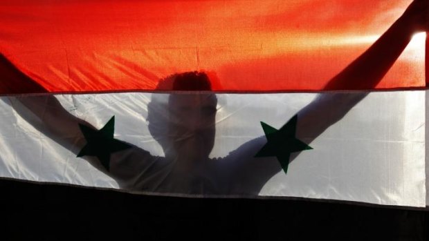 A demonstrator holds a Syrian flag during a protest against a possible military strike against Syria by the US.