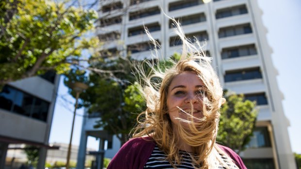 Laura Corrigan, of Holder, tries to tame her hair in the wind in Woden Square on Thursday. 