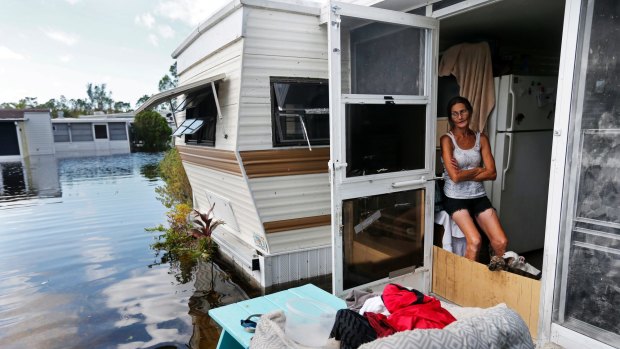 Cherie Ethier sits in her mobile home with her pets surrounded by floodwater in Naples, Florida.
