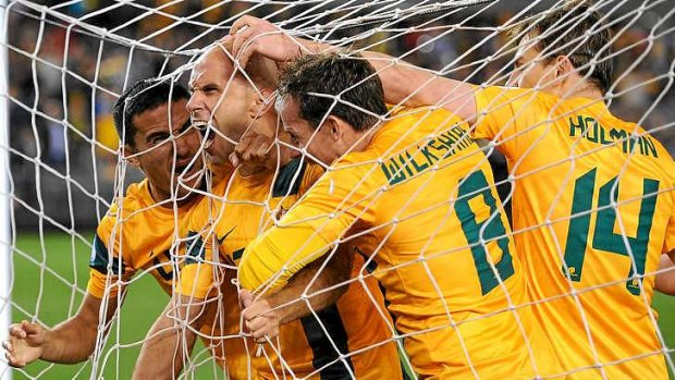 Net bulger: Mark Bresciano and the Socceroos celebrate scoring the opening goal against Jordan in Melbourne on Tuesday night.