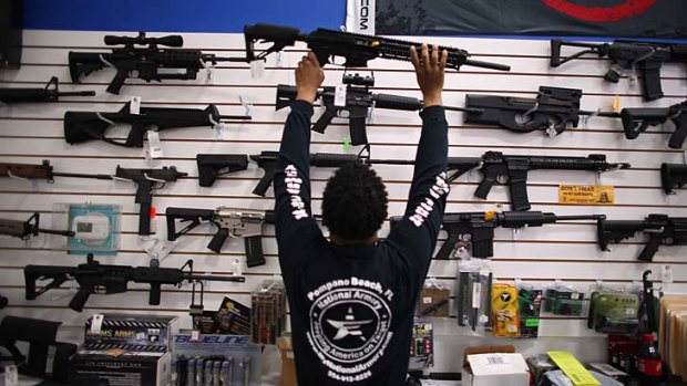 Holding on: Mike Acevedo returns a weapon to its display at the National Armory store in Pompano Beach, Florida.