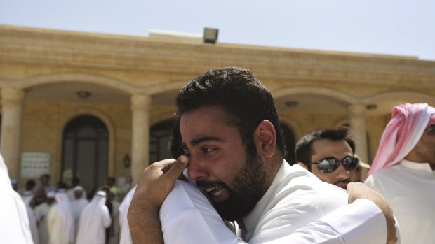 Relatives of the victims of Friday bombing console each other at the Al Jafariya cemetery in Suleibikhat, Kuwait.