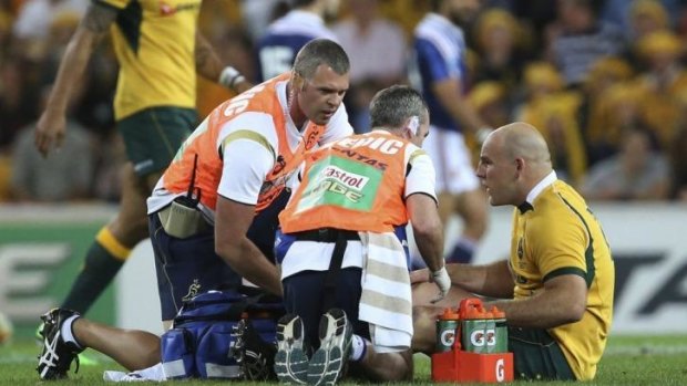 Emotional ride ahead: Stephen Moore receives treatment for his injury during the Test against France.