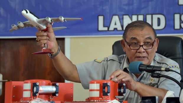 Tatang Kurniadi, the head of the National Transportation Safety Committee, with the flight data recorder (on right of table) and cockpit voice recorder (on left of table) in Pangkalan Bun, Indonesia.