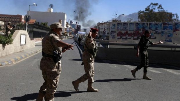 Brazen attack: Yemeni soldiers set up a cordon on the road leading to the Defence Ministry compound.