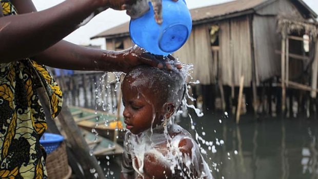 A woman bathes her child in the Makoko fishing community in Nigeria's commercial capital Lagos.