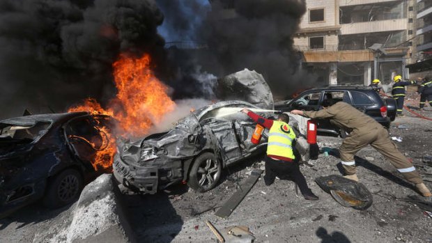 Dousing the flame: Lebanese firefighters extinguish cars at the site of the explosion in southern Beirut.