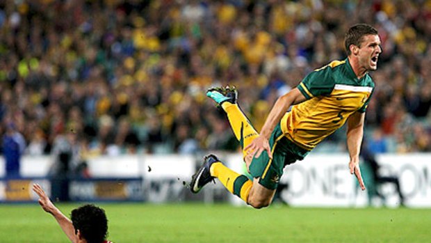 Jason Culina is airborne after a foul in the clash against Paraguay.