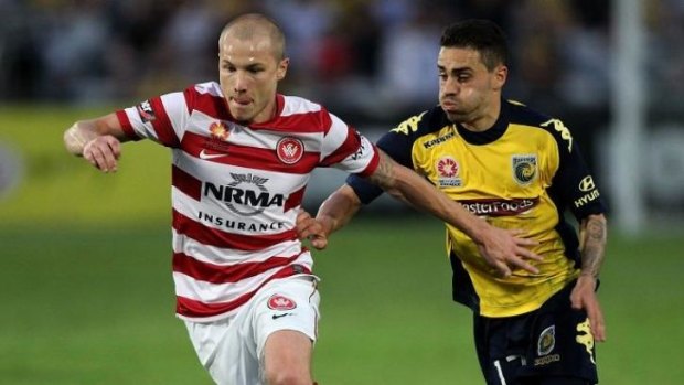 Familiar foes: Aaron Mooy controls possession for the Wanderers under pressure from Mariners counterpart Anthony Caceres.