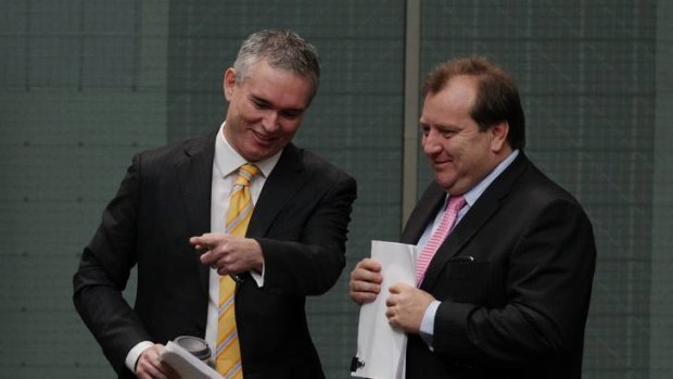 Independent MP Craig Thomson speaks with Labor MP Rob Mitchell, during a division in the House of Representatives, in which Craig Thomson voted with the Opposition.