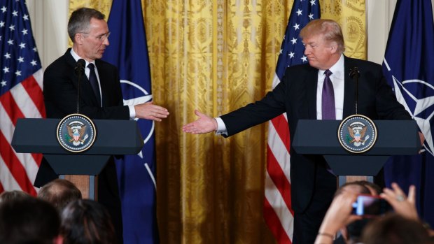 President Donald Trump reaches to shake hands with NATO Secretary General Jens Stoltenberg during a news conference.