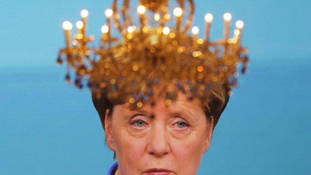 A chandelier sits in front of a screen showing German Chancellor Angela Merkel during the TV debate