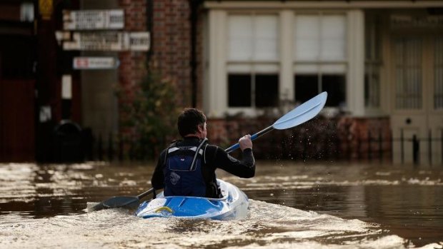A man canoes along the town centre streets in Yalding, England.