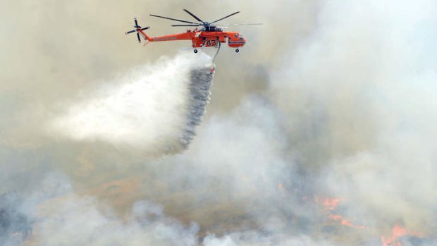 'Godsend': A water bombing helicopter in action. The Rural Fire Service is sceptical of the need to buy rather than lease the aircraft.