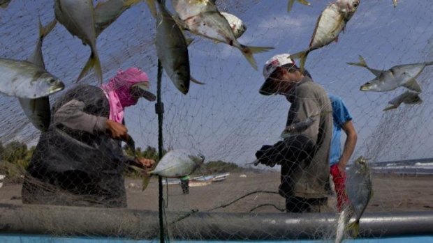 Fishermen clean their fishing net in the hometown of sea survivor Jose Salvador Alvarenga.
