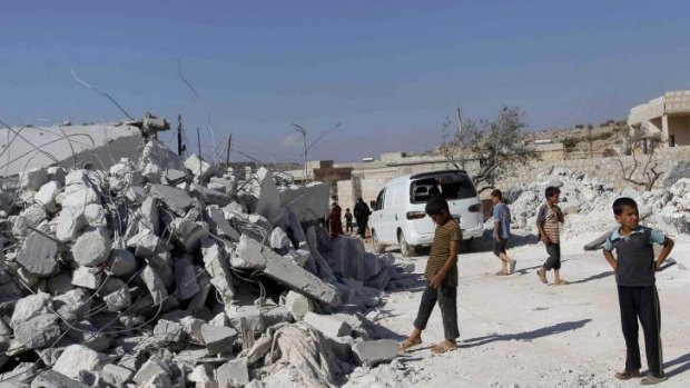 Residents inspect damaged buildings in what activists say was a US strike, in Kfredrian, Idlib province, Syria.