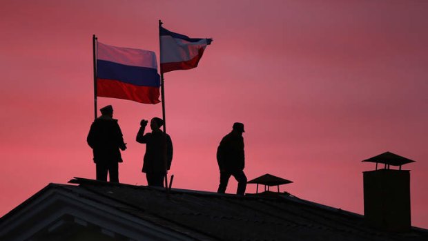 Cossack men install a Russian flag in Crimea.