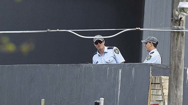Six-hour siege ... police officers look at a handgun on the ledge of a building inside the cordoned off area.